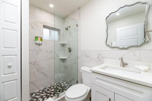 Un baño con inodoro, lavabo y espejo. en The Hideaway at Lake Ridge 1, en Fort Lauderdale
