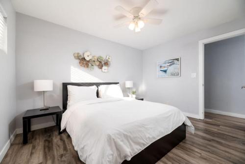 um quarto branco com uma cama e uma ventoinha de tecto em The Palms at Middle River Terrace 4 em Fort Lauderdale