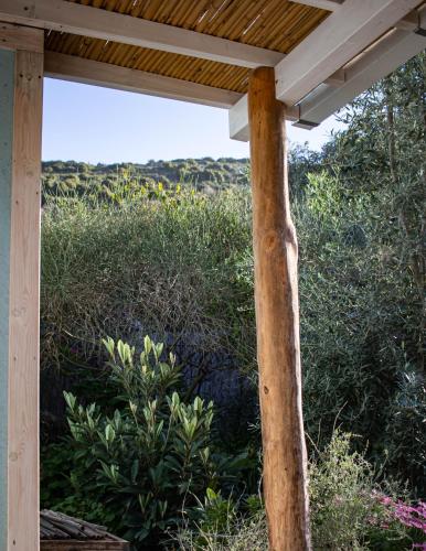 a wooden pergola with a view of a field at Blue House In The Woods- Amirim in Amirim