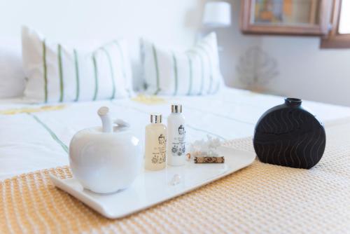 a tray with three bottles and a candle on a bed at Finca Olivar de Castilla - Sun&Colors in Segovia