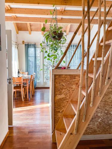 a wooden staircase in a room with a dining room at Blue House In The Woods- Amirim in Amirim