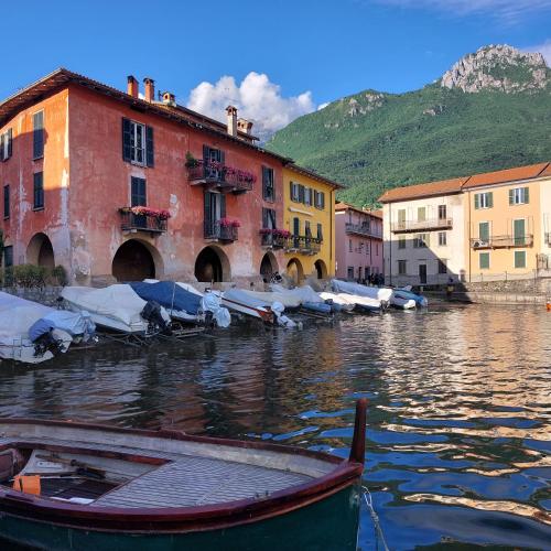 a boat sitting in the water next to buildings at Casa Vacanza Nonno Gigi in Mandello del Lario