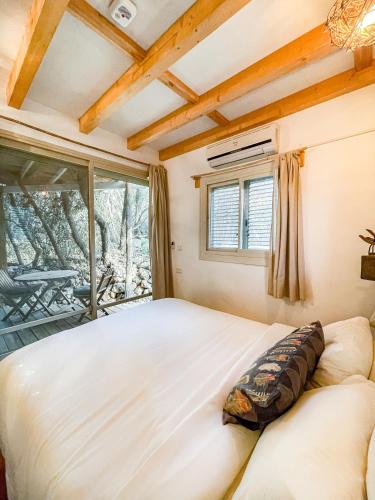 a bedroom with a large bed and a window at Blue House In The Woods- Amirim in Amirim