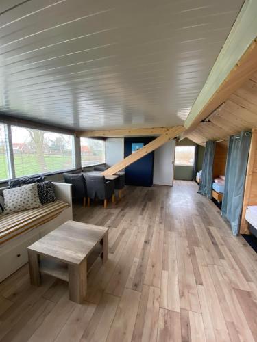 a large living room with a couch and a table at Groepsverblijf "De Klosse" in Wanneperveen