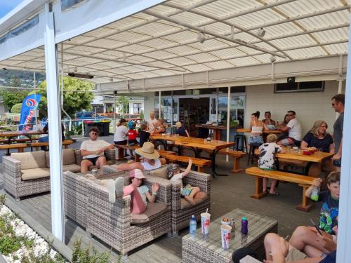 a group of people sitting on couches in a patio at Tāhuna Beach Holiday Park in Nelson