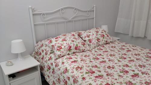 1 dormitorio con 1 cama con colcha de flores en Nuevo apartamento Montelouro en Louro