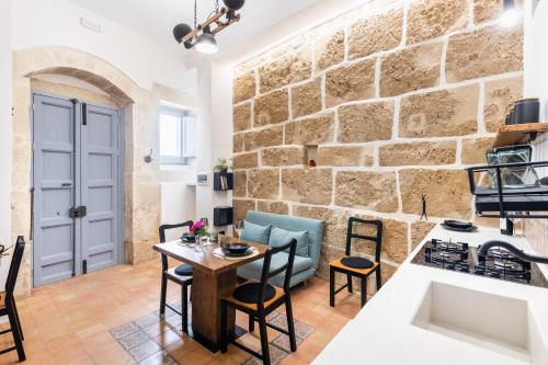 a kitchen and dining room with a stone wall at Othila Home in Noto