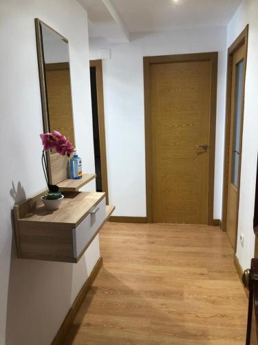 a hallway with a mirror and a wooden door at BRiSaS DeL NoRTe in Gijón