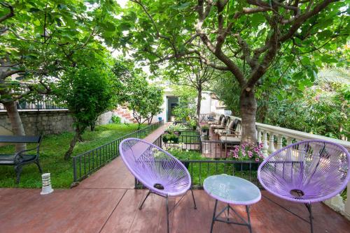 two purple chairs and a table on a deck at Apartments Kiki in Kotor