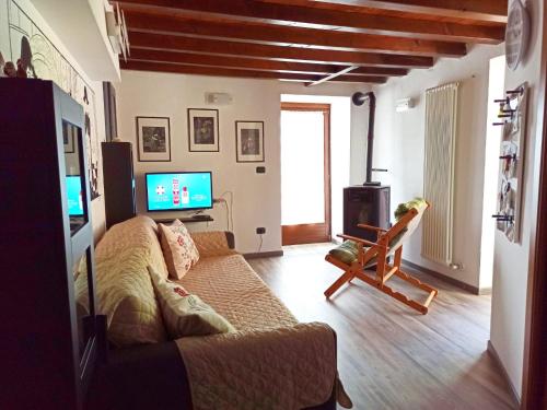 ein Wohnzimmer mit einem Sofa und einem TV in der Unterkunft Maison Bellevue - locazione turistica breve in Aosta