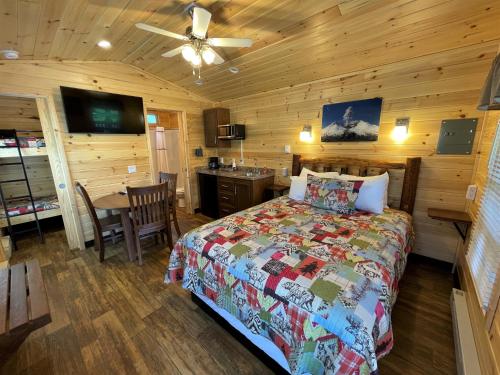 a bedroom with a bed and a table in a cabin at Lone Fir Resort in Cougar