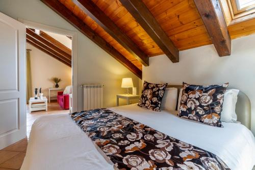 a bedroom with a large bed in a room with wooden ceilings at Baba Residences in Alassio