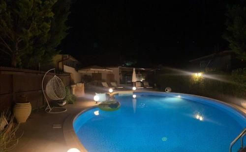 a large blue swimming pool at night with lights at Luxury Villas Chrysa Private Pool & Spa in Nafplio