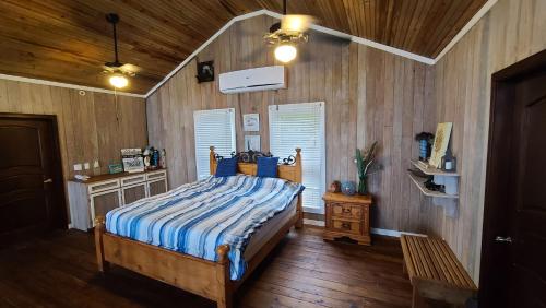 une chambre avec un lit et un mur en bois dans l'établissement Coral Beach Village Resort, à Utila