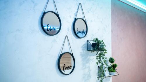 three mirrors hanging on a wall with plants at Alpin Apartments Vlašić in Vlasic