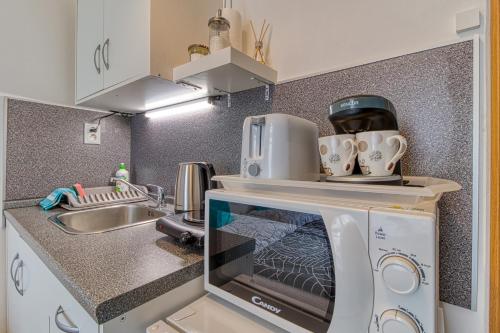 a kitchen with a microwave and a sink at JonasHouse studios - Great Location near Bratislava City Center in Bratislava