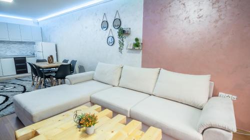 a living room with a white couch and a table at Alpin Apartments Vlašić in Vlasic