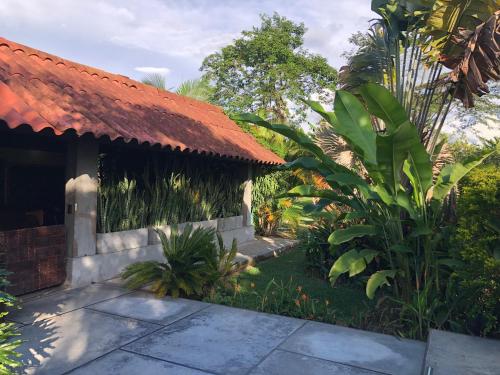 a house with a red roof and some plants at Finca Hotel Brasilia in La Tebaida