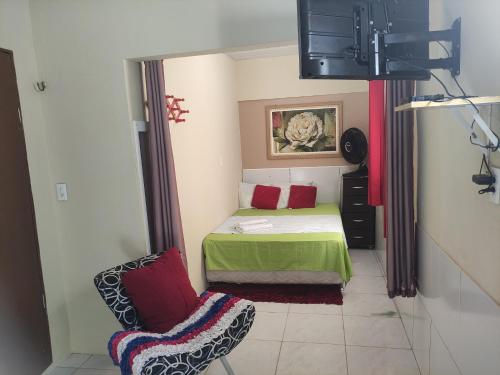 a small bedroom with a bed and a chair at Cantinho Morro Branco in Beberibe