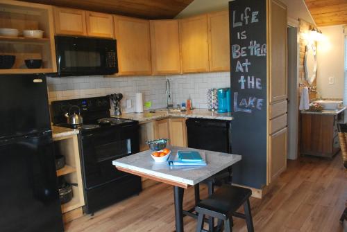 a kitchen with a table and a black refrigerator at Lake Front cottage in Little Elm