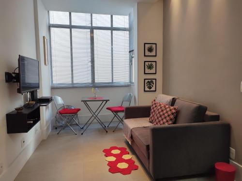 uma sala de estar com um sofá e uma mesa em Charmoso Studio Leblon no Rio de Janeiro