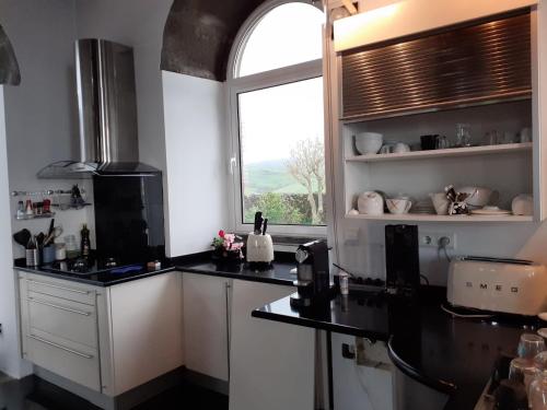 a kitchen with a sink and a window in it at A QUINTA DAS FLORES- Casa do Miradouro in Santa Cruz das Flores