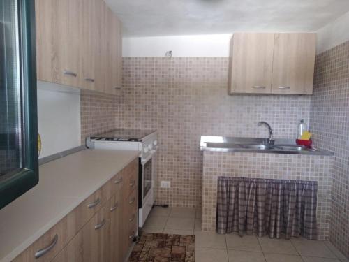 eine Küche mit Holzschränken und einem Waschbecken in der Unterkunft Casa vacanze in Valle D'Itria in Ceglie Messapica