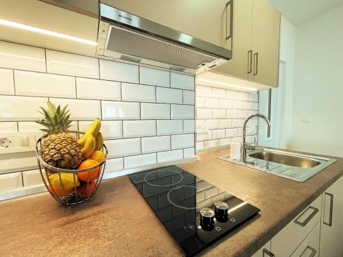 - un bol de fruits sur un comptoir dans la cuisine dans l'établissement Apartments Sunset, à Mlini