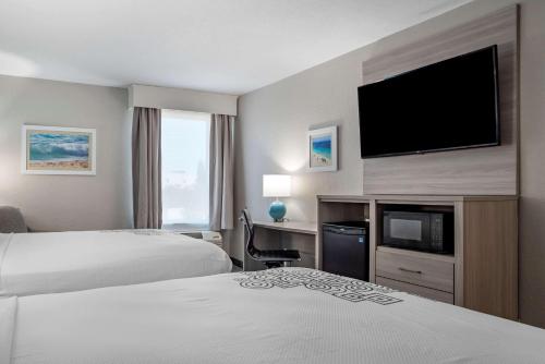 a hotel room with two beds and a flat screen tv at Best Western Plus Panama City Hotel in Panama City