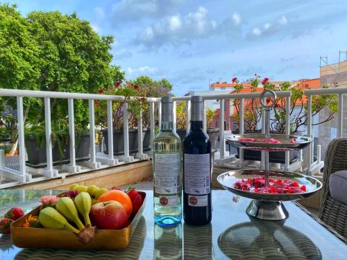 Cascais Sun Apartment في كاسكايس: زجاجة من النبيذ ووعاء من الفواكه على طاولة