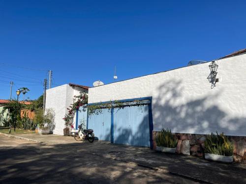 un edificio blanco con una puerta azul a un lado en Pouso do Rio, en Pirenópolis