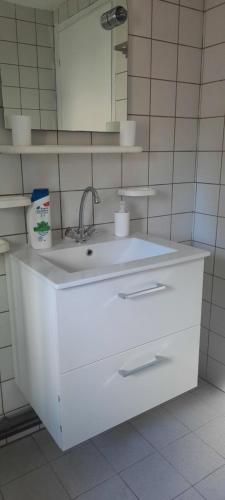 a white bathroom with a sink and a mirror at Maison en Location Fresnes sur Marne in Fresnes-sur-Marne