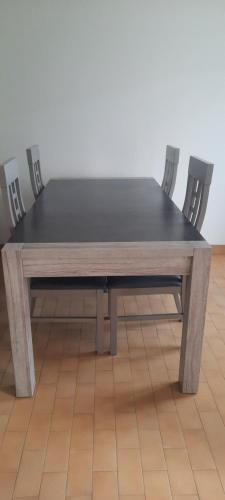 - une table en bois avec deux chaises assises à côté dans l'établissement Maison en Location Fresnes sur Marne, à Fresnes-sur-Marne