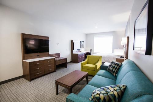 a living room with a couch and a tv in a hotel room at Holiday Inn Hotel & Suites Calgary South - Conference Ctr by IHG in Calgary