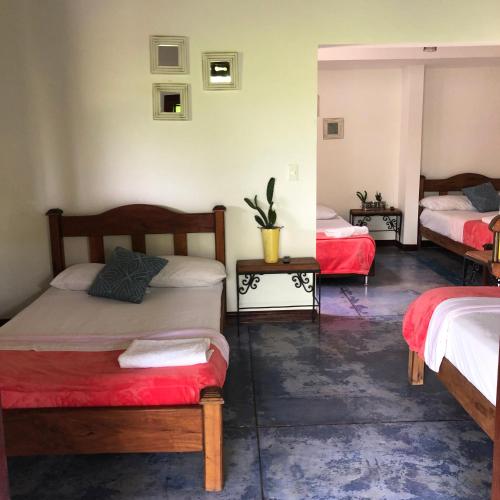 a room with two beds and two tables at Finca Hotel Brasilia in La Tebaida