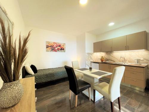 een keuken en een woonkamer met een tafel en stoelen bij Villa Sunset in Mlini