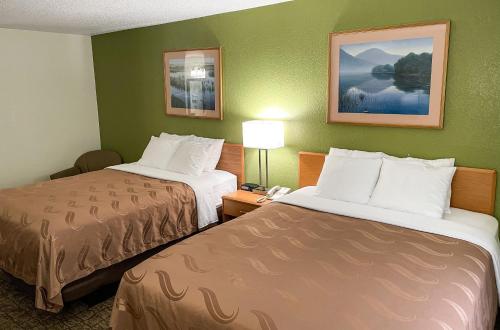 a hotel room with two beds and a lamp at Hudson Inn & Suites in Hudson