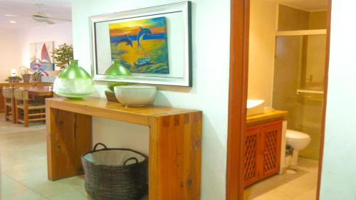 a room with a table with a painting on the wall at Los Tules Ocean Front Condo ,With Amazing Ocean View by Kivoya in Puerto Vallarta