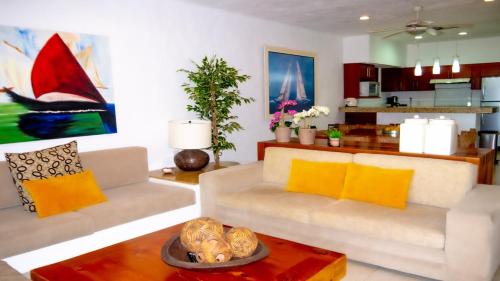 a living room with a white couch and yellow pillows at Los Tules Ocean Front Condo ,With Amazing Ocean View by Kivoya in Puerto Vallarta