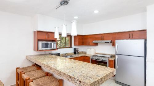 a kitchen with a white refrigerator and a counter top at Los Tules Ocean Front Condo ,With Amazing Ocean View by Kivoya in Puerto Vallarta