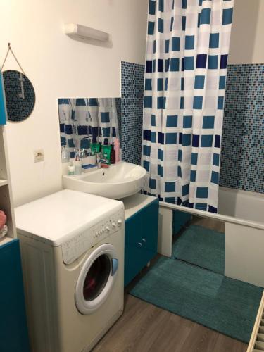 une machine à laver dans une salle de bain avec un lavabo dans l'établissement Chambre Simple privée Saint Priest, à Saint-Priest