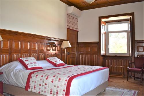 Schlafzimmer mit einem Bett mit roten Kissen und einem Fenster in der Unterkunft Quinta da Marmela in Torres Novas