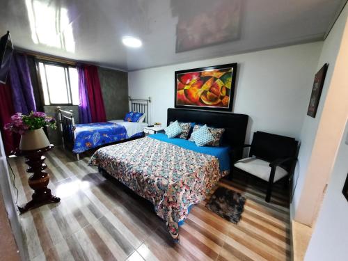a bedroom with a bed and a chair at Hotel Recreacional Marcelandia Santa Rosa de Cabal in Santa Rosa de Cabal