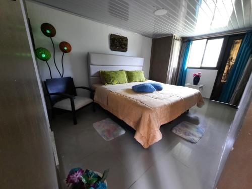 a bedroom with a bed with a chair and a window at Hotel Recreacional Marcelandia Santa Rosa de Cabal in Santa Rosa de Cabal