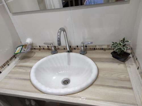 a white sink in a bathroom with a mirror at Ezeiza 3 departamento privado a 15 minutos del aeropuerto hasta 7 personas OPCIONAL TRANFER DESDE Y HACIA EL AEROPUERTO DE EZEIZA LAS 24 HORAS pet friendly conexion con Aeroparque in Ezeiza