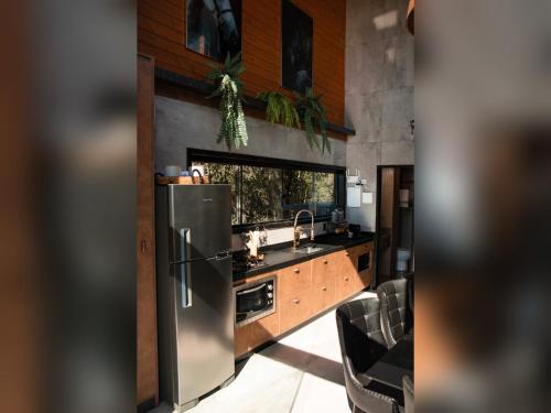 a kitchen with a stainless steel refrigerator and a sink at CABANA HORSES LA CONTEMPORANEA- vista ponto turístico Pedra Morro do Campestre -Asfalto até a Cabana in Urubici
