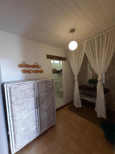 a living room with white curtains and a bird cage at Hotel Recreacional Marcelandia Santa Rosa de Cabal in Santa Rosa de Cabal