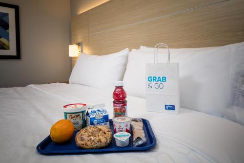 a tray with food and drinks on a bed at Holiday Inn Express & Suites - Bend South by IHG in Bend