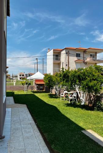 a grassy yard with a building and a tent at Villa Ilias in Flogita