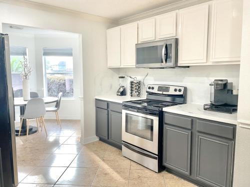 a kitchen with white cabinets and a stove top oven at Modern Chic Home in Channelview
